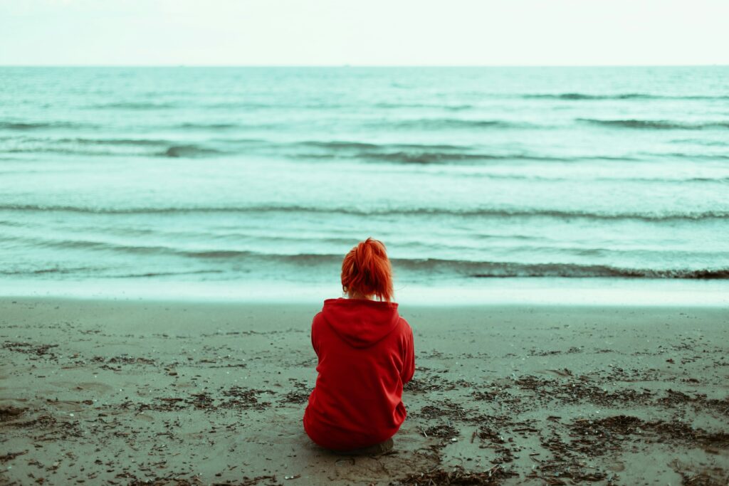 Femme anxieuse sur une plage, face à l'océan