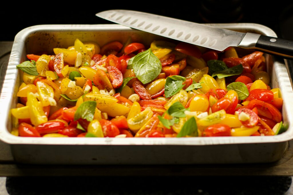 Des tomates cerises, du basilic et un couteau dans un plat de cuisine, pour gérer son alimentation