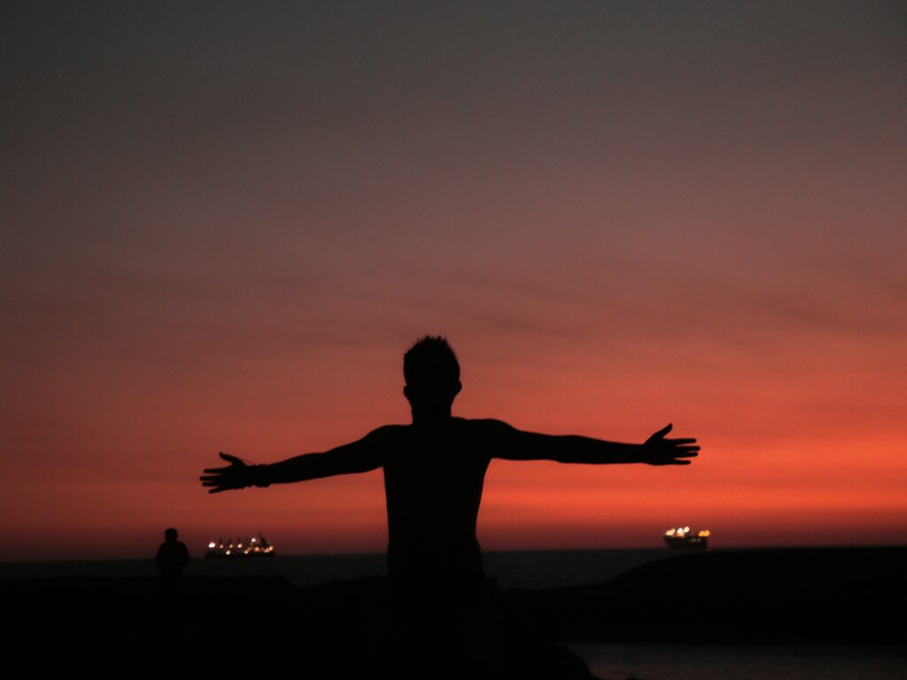 Un homme qui termine ses exercices pour soulager son anxiété, face au coucher de soleil